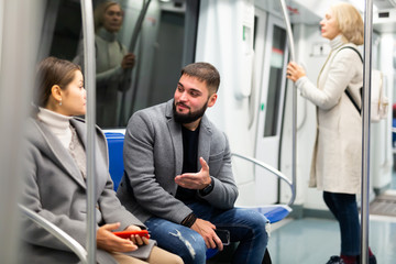 Fototapeta na wymiar Guy enjoying conversation with woman in subway train