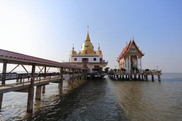 Fototapeta na wymiar Gold pagoda and church located in the sea at Hong Thong Temple, Chachoengsao, Thailand