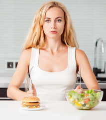 Obraz na płótnie Canvas Woman chooses between a healthy and unhealthy food