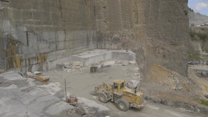 Digger working in a black granite quarry