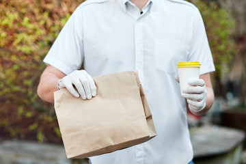 Courier, delivery man in protective mask and medical gloves during the coronavirus epidemic.