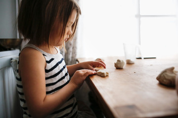 Girl child sculpts from salt dough, creativity