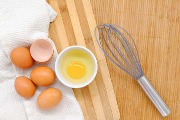 Close-up view of raw chicken eggs on wooden background
