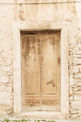 Dubrovnik, Croatia, 2019. Stone building with old vintage beige wooden door. Travel concept.
