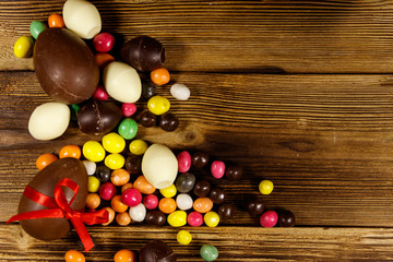 Easter composition with chocolate eggs on wooden background