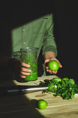 Man hold healthy detox smoothie, cooking with blender with fresh fruits and greens spinach,  Lifestyle detox concept. Vegan drinks. Lifestyle detox concept. Vegan drinks..