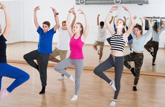 Dance teacher showing stretching position to teenagers