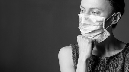 Girl wears protective mask. Coronavirus. Close up portrait of young woman wearing medical mask, black and white