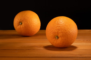 fresh oranges on the wooden table and black background