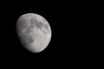 Incomplete moon in the telescope on a black background of the night