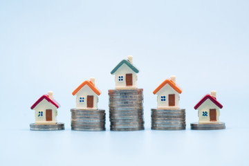 Mini house on stack of coins, Concept of Investment property, Investment risk and uncertainty in...