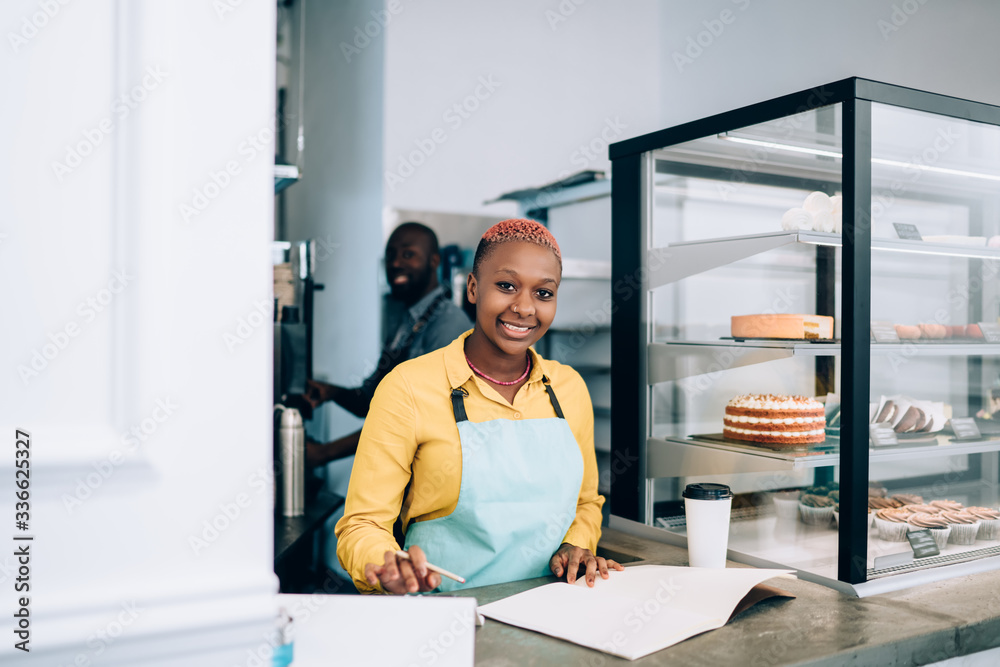 Wall mural Bright waitress writing down cafe assortment