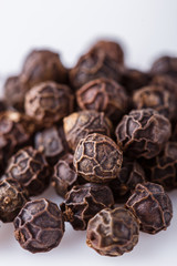 fragrant black pepper on white acrylic background