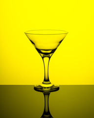 Empty wine glass on a yellow background