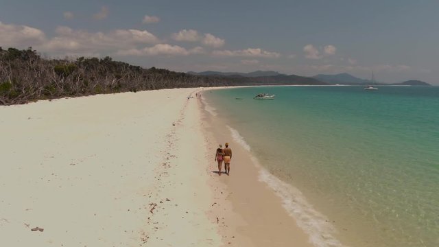Couple on Beach, Turquoise ocean, white sand DRONE view. Aerial of Whitehaven beach , Whitsundays. Dramatic view. Travel, holiday, vacation, paradise, exotic, romantic, honeymoon. Queenstown Australia