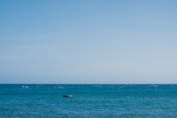 Wooden small boat in the sea landscape with endless horizon
