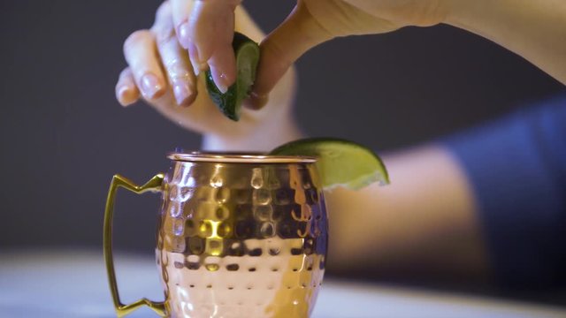 hand squeezed lime on Moscow Mule cocktail in typical copper mug