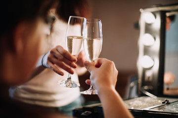bride and bridesmaid clink champagne glasses on wedding day