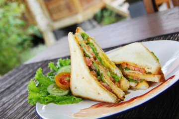 Sandwich with beef,tomato and lettuce on platter. A breakfast menu photography.
