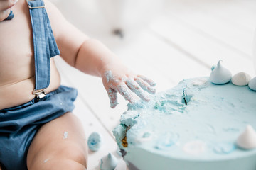 Little baby boy, celebrating his first birthday with smash cake party, studio isolated shot on white background