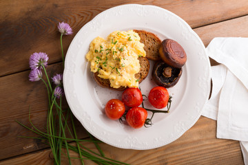 scramble egg with grilled tomatoes and mushrooms. breakfast.