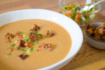 Food photography of a chilled Spanish gazpacho soup in a white bowl.