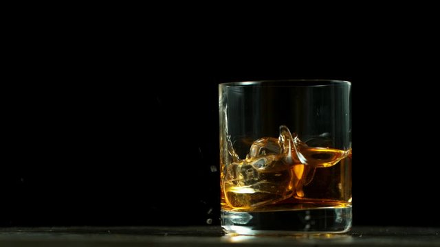 Super slow motion of falling glass of whiskey, being destructed. Filmed on high speed cinema camera, 1000 fps.