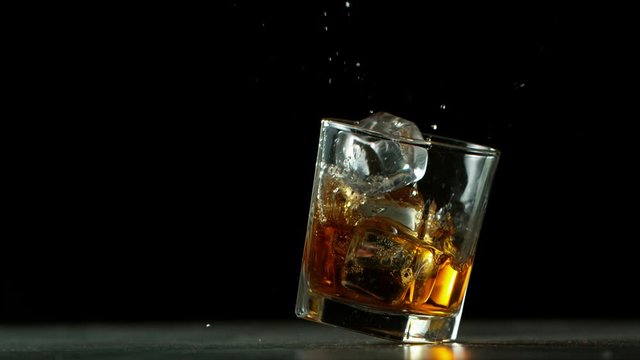Super slow motion of falling glass of whiskey, being destructed. Filmed on high speed cinema camera, 1000 fps.