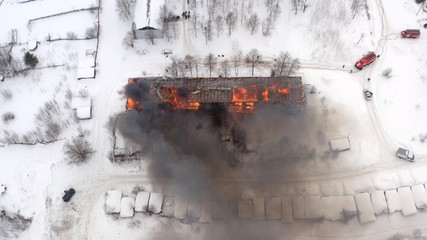 Aerial view the burning roof of the building in winter.