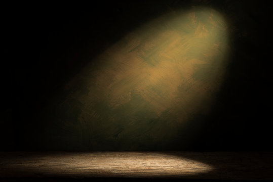 Old Wood Table With Blurred Concrete Block Wall In Dark Room Background.