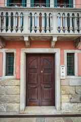 Old wooden door and balcony in italian traditional house