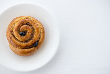 Round cinnamon roll on a white plate