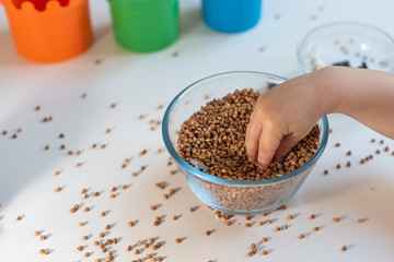 the child develops fine motor skills of hands getting small parts from a container filled with cereals