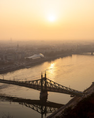 Warm sunrise image of Budapest with a Liberty bridge view and reflections in Danube river