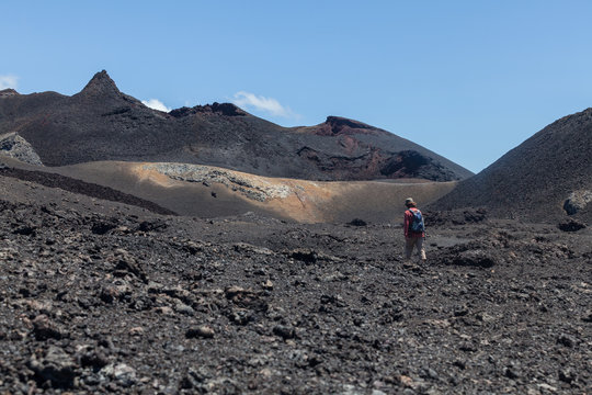 tourist trekking lava fields after eruption volcano chiko sierra negra caldera