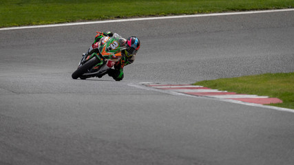 A shot of a multicoloured racing bike speeding round corners