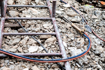 Oxy Acetylene Oxy-fuel welding and cutting head tool on the ground at construction site.