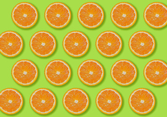 Image of patterned fresh orange sliced on light green background