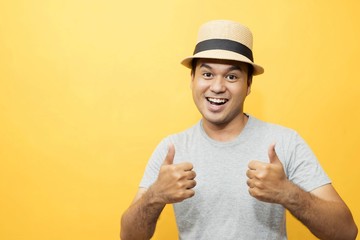 A handsome man in a good mood standing on a yellow background