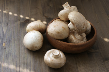 Champignon mushrooms in wood bowl