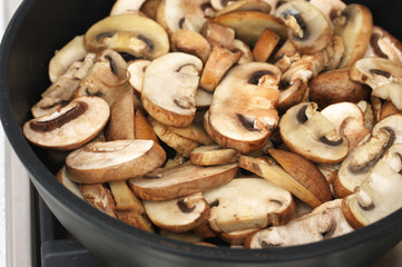 Chopped champignon mushrooms frying in pan