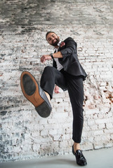 man in black suit .on a  brick background make big step