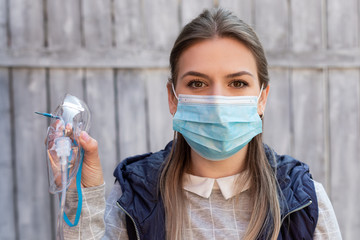 Woman holding oxygen mask outside