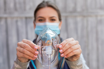 Woman holding oxygen mask outside