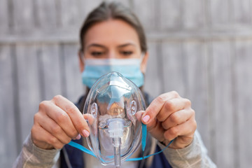 Woman holding oxygen mask outside