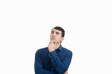 Portrait of unsure, perplexed man looking up and thinking for a solution. Thoughtful expression of a young man over white background.