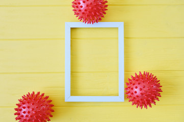 Abstract red balls virus strain model with wooden frame mockup on yellow background. Respiratory syndrome coronavirus and Novel covid-19 with place for text background