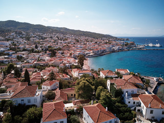 Naklejka na ściany i meble Aerial shot of Spetses Island coast in Greece. A famous tourist destination on the Aegean sea. Old town and harbour view.
