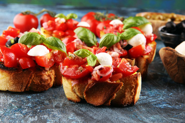 Traditional italian bruschetta with cherry tomatoes, cream cheese, basil leaves on rustic...