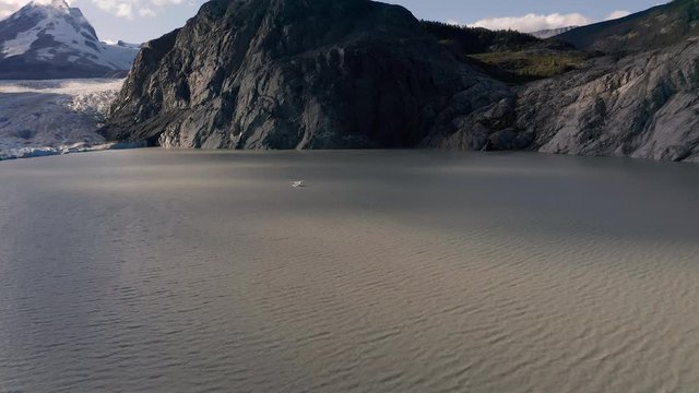 A drone shot of a Sea plane on a glacier lake in the mountains of British Columbia before take off